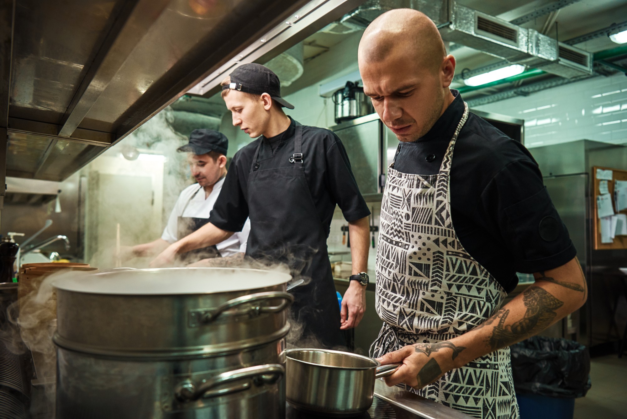 Team bereitet Suppen in großen Töpfen